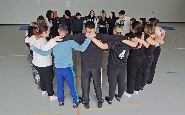 Les élèves de TASSP, en cercle, s'encouragent pour la représentation de danse. 